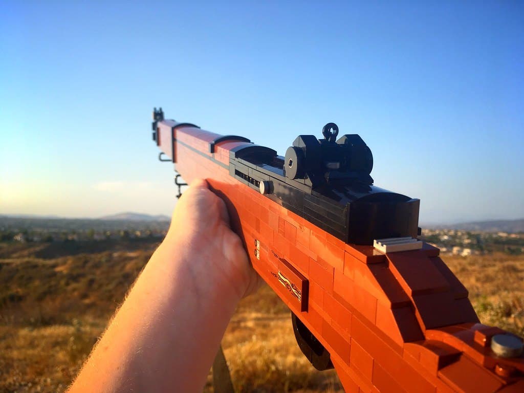 The LEGO M1 Garand held out over dry hills at sunset